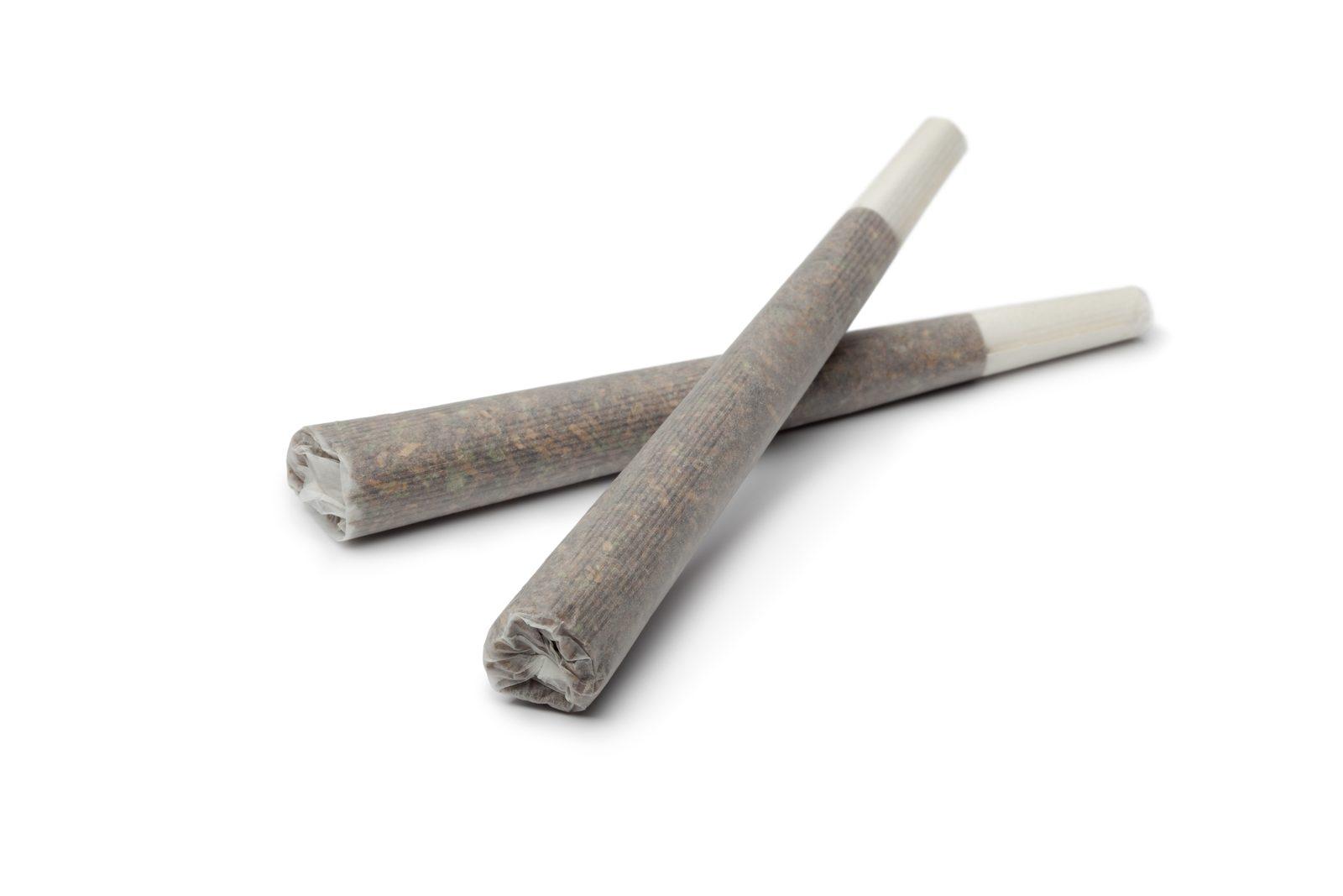 Two rolling cigarettes on a white surface